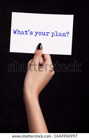 hand holding white card on black background - what' your plan