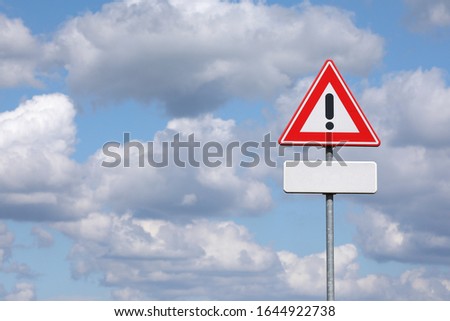 A sign with a exclamation mark warning for a dangerous situation ahead. At the bottom a smaller sign on which an editor can place a text