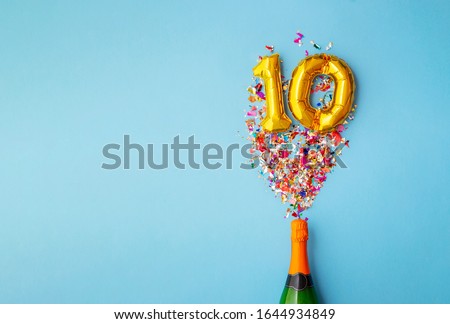 10th anniversary champagne bottle balloon pop Royalty-Free Stock Photo #1644934849