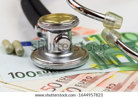 Close-up view of stethoscope and euro banknotes on white background