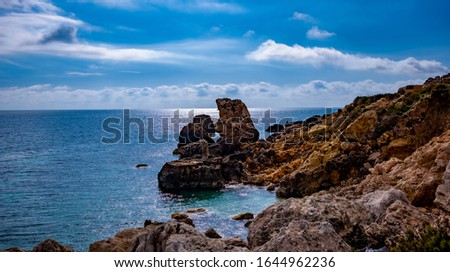 A background wallpaper picture of rocky beach in the island of Malta witch the beautiful blue sky and blue sea a favorite area for tourist in the Mediterranean 