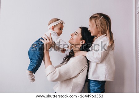 Mother and child . Mom and baby girl playing in sunny room. Mother and child girl playing, kissing and hugging.