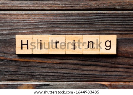 hiring word written on wood block. hiring text on table, concept.