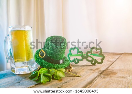 St. Patricks Day green shamrocks with a full cold frosty glass of beer 

background