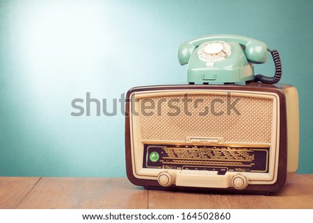 Retro old radio and mint green telephone on wooden table