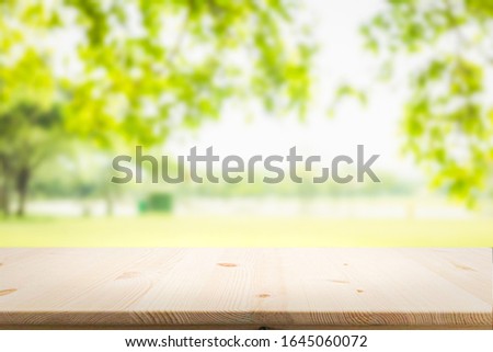 Empty wooden table with garden bokeh for a catering or food background with a country outdoor theme,Template mock up for display of product Royalty-Free Stock Photo #1645060072