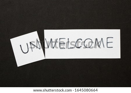 Changing word Unwelcome transformed to Welcome on a white sheet. Royalty-Free Stock Photo #1645080664