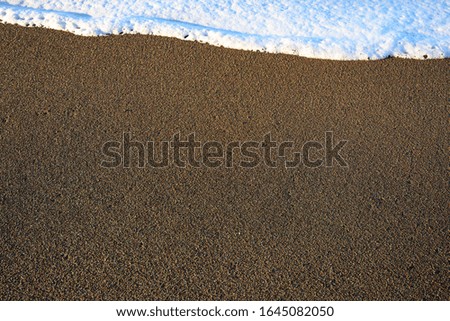 White Waves Atop Sand Texture with copy space