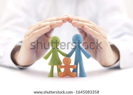 Family insurance concept with colorful family figurines covered by hands Royalty-Free Stock Photo #1645083358