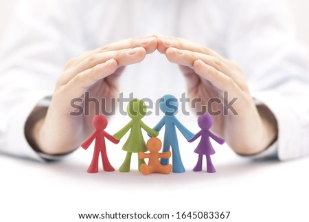 Family insurance concept with colorful family figurines covered by hands Royalty-Free Stock Photo #1645083367
