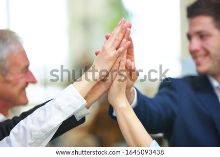 Successful business team gives itself high five in the office
