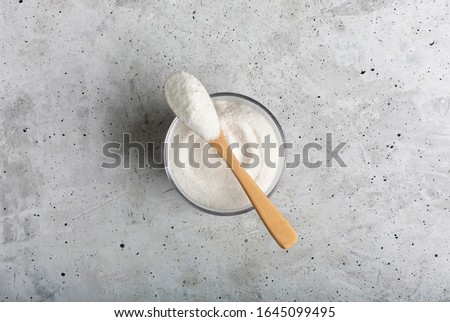 Closeup collagen in a glass with a spoon, on concrete background. Royalty-Free Stock Photo #1645099495