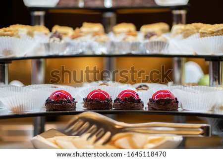 Mix of sweets, cakes, muffins. Beautifully laid out on a glass showcase. Setout.