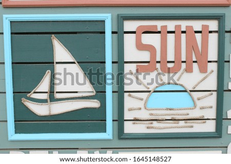Wooden sign with the inscription Sun, summer pattern, sailing boat. Concept of summer vacation on the beach.