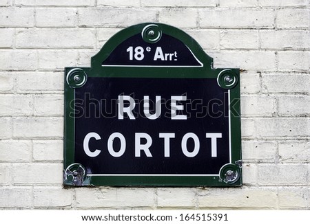 Traditional Paris plaque with street name on white brick wall