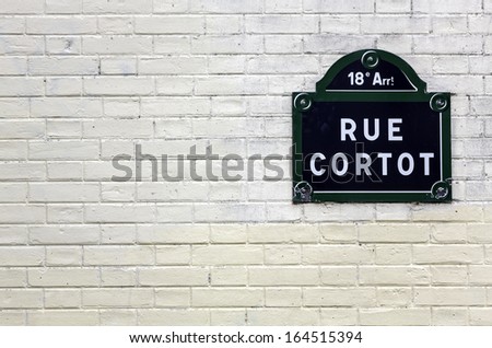Traditional Paris plaque with the name of the street on white brick wall