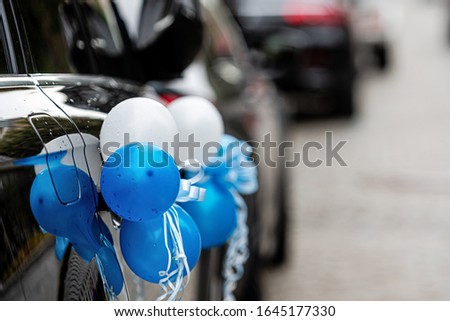 car with blue and white balloons to bring newborn baby home from maternity hospital - image