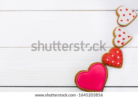 Flat lay made of heart-shaped gingerbread cookies on the white wooden background. Concept for Valentine's Day, 8 March,Birthday. Copy space for greeting