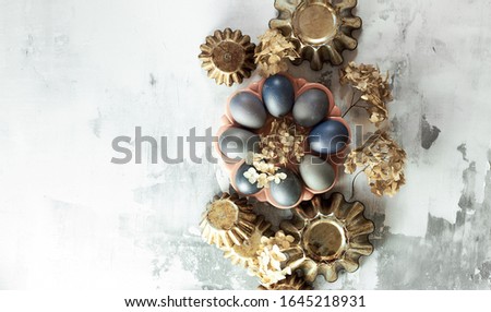 Easter composition from blue eggs, cake forms, dry flowers on concrete background, copy space, Christian religious festival concept and design