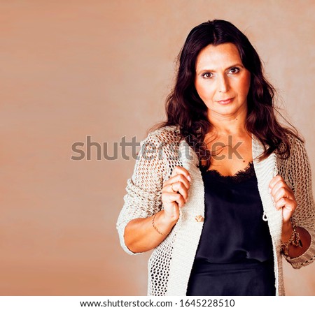 pretty brunette confident mature woman posing cheerful on warm brown background, lifestyle people concept