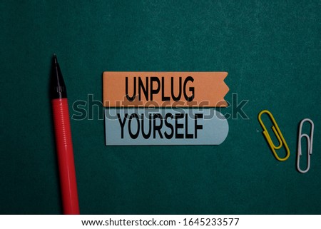 Unplug Yourself write on a sticky note isolated on Office Desk