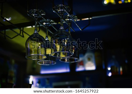 Glass goblets hang on a bar counter