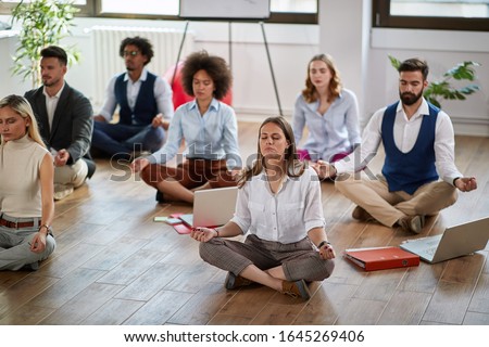 group of business coworkers meditating at work, sitting on the floor. modern, business, meditation  Royalty-Free Stock Photo #1645269406