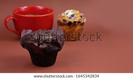 Chocolate muffin stock images. Chocolate muffin isolated on a brown background with copy space for text. Various muffins and cup of coffee stock images. Chocolate muffin frame. Breakfast still life