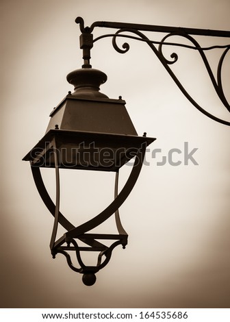 Vintage lantern with water drops after rain. Loneliness concept. Sepia. Shadowed angles.