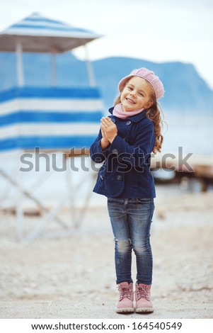 Portrait of 4 years old girl walking near sea in the city, still life photo