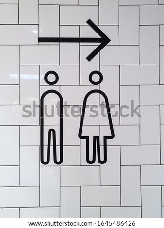 Men and women toilet signs on white wall background.