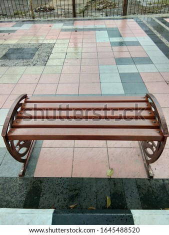 The waiting bench on the side of the road is brown