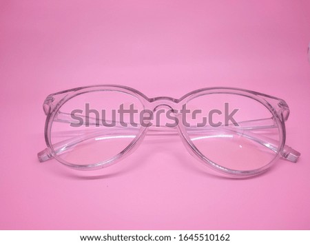 modern eye glasses isolated on pink background, top view