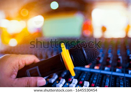 Blurred microphone on and sound mixing console control blurred background