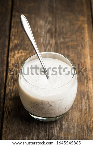 Plain yogurt with chia seeds in glass on the rustic wooden background. Selective focus.