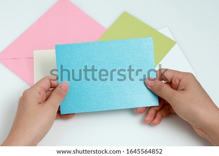 Female hand holding blank blue greeting card for text.