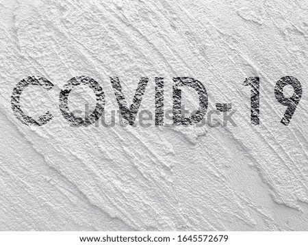 Covid-19 lettering on white concrete wall background. Coronavirus concept background