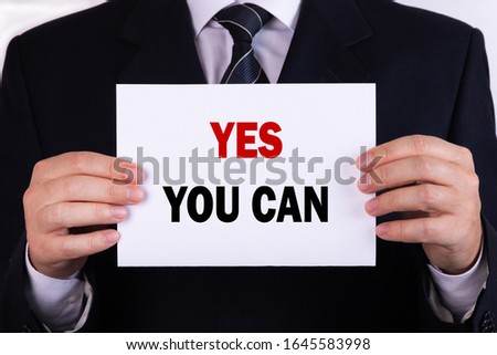 Businessman holding a card with text yes you can