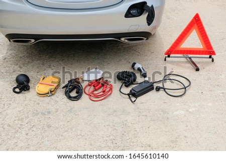 Basic emergency tool kit and portable charger for plug-in hybrid car.