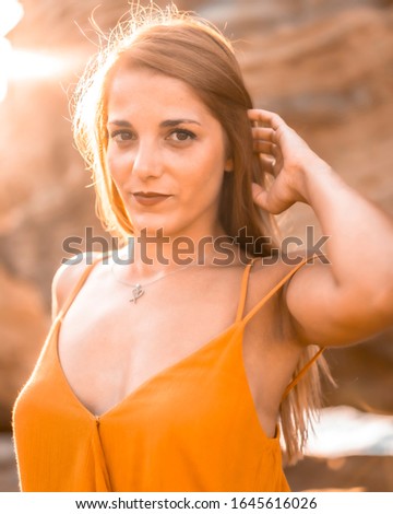 Lifestyle portrait, young woman in an orange dress with on a hot afternoon