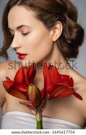 Beautiful brunette demonstrating her profile, shooting with bright flower