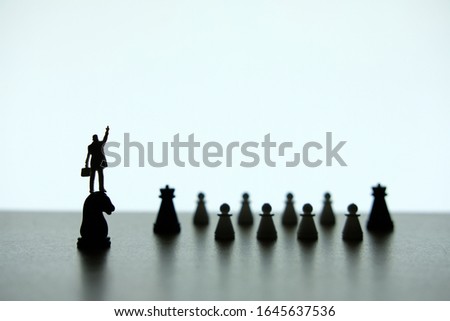 Business strategy conceptual photo - Silhouette of miniature businessman pointing upside, standing on a chess piece of horse
