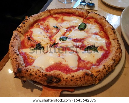 Pizza Margherita, typical Neapolitan pizza, made with San Marzano tomatoes, mozzarella cheese, fresh basil, salt and extra-virgin olive oil. Famous and cozy Italian restaurant in Seoul, South Korea.
