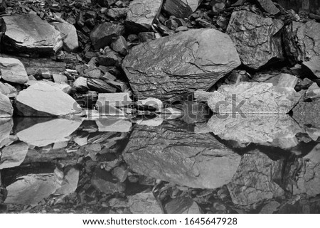 perfect reflection of stones in smooth water. Picture for wallpaper, background