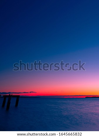 Tranquil Bay with Pilings of Ruined Pier at Twilight