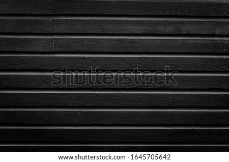 Dark black grungy stalled wood wall texture background.