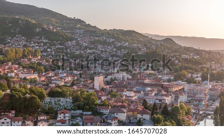 Panoramic aerial cityscape of the historical downtown of Sarajevo timelapse, Bosnia and Herzegovina, with famous buildings and the bridges across Miljacka river before sunset from viewpoint