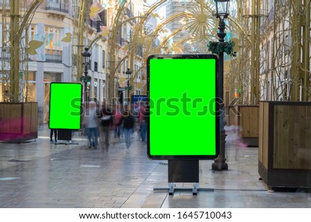 Street Billboard sign with green screen , Mock up of an Outdoor Billboard Advertisement against busy pedestrian street blurred on purpose in historical center of,european city