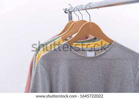  fashion and ad concept. Hanger with row of t-shirts 
on hanging 

