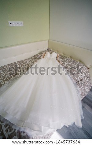 Beautiful wedding dress lies on the bed.